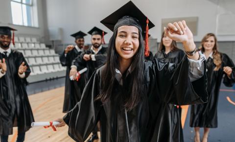 Group of happy students in graduation caps and gowns