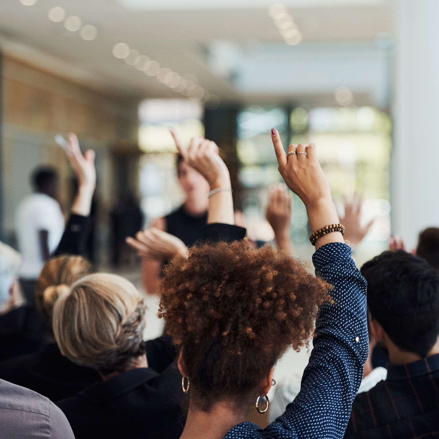 A crowd raising their hands for questions