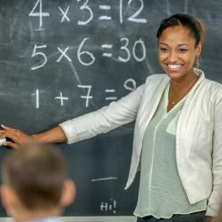 A female math teacher demonstrating at the chalkboard