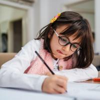 Girl concentrating on her homework while writing