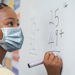 Girl doing math at chalkboard
