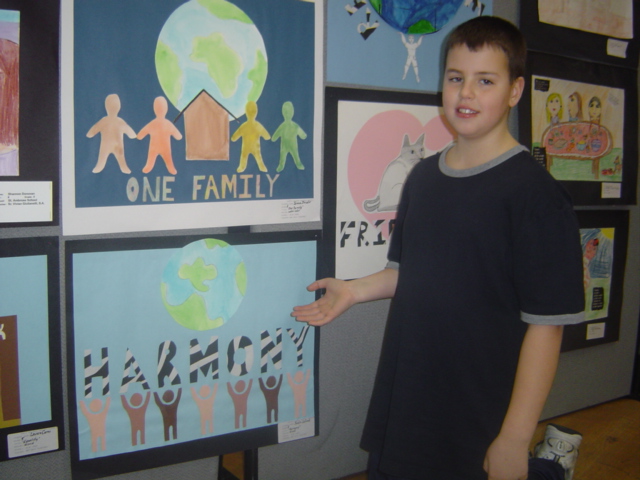 A young Justin standing in front of a school art display.