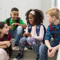 Four pre-teens laughing together after school