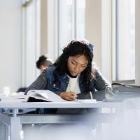 Teen studying at a table.