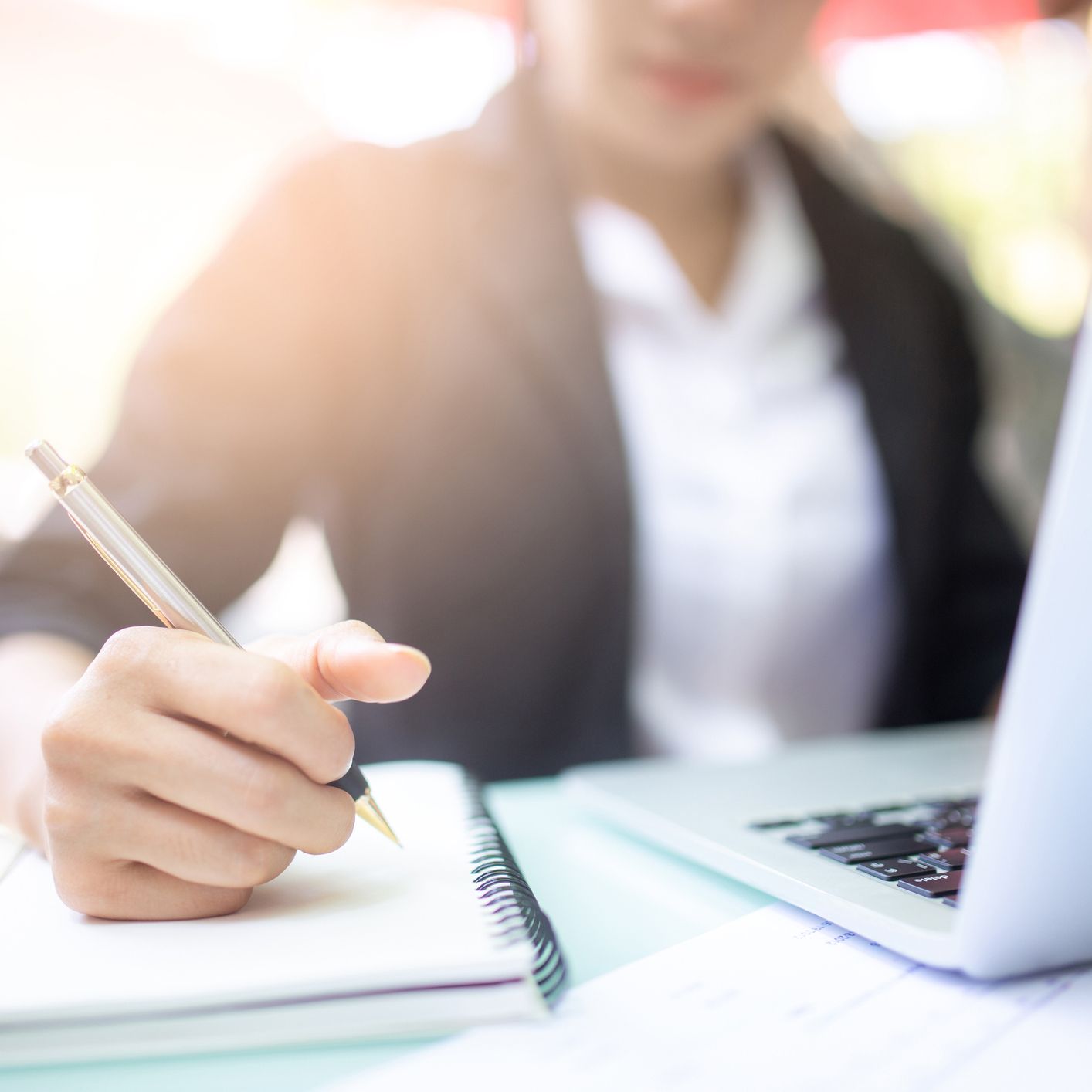 Woman at computer taking notes